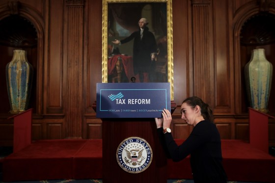 Image: A staff member sets the stage before a GOP news conference on tax reform