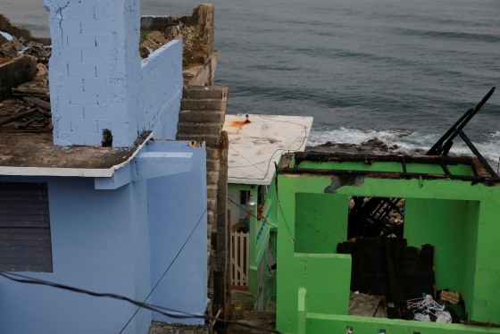 Image: A woman stares from the porch of a home in the Hurricane Maria damaged La Perla of Old San Juan in San Juan, Puerto Rico