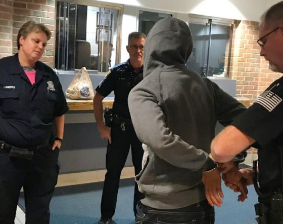 Image: Michael Zaydek, known on social media as Champagne Torino is handcuffed at the Redford Township Police Department