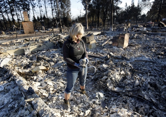 Image: Debbie Wolfe dumps ashes from a pot she found in the burned ruins of her home
