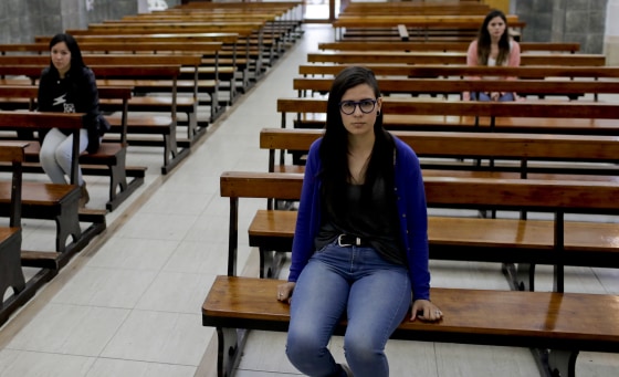 Karen Maydana, center, Mailin Gobbo, behind right, and Yasmin Detez, behind left, pose for a photo at San Jose Obrero church in Caseros, in the province of Buenos Aires, Argentina. The schoolmates returned to the church and adjacent school they'd attended to describe being allegedly assaulted as children by Rev. Carlos Jose.