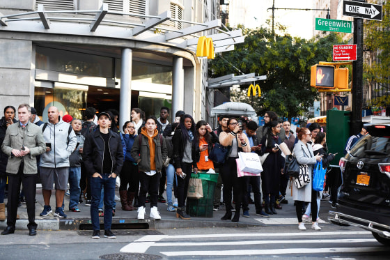 Image: A crowd watches as polioce investigte a shooting in downtown New YOrk
