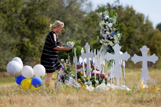 Image: A woman places flowers at a memorial in memory of the victims killed in the shooting at the First Baptist Church of Sutherland in Sutherland Springs