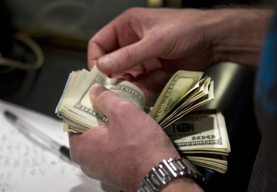 Image: A man counts out $100 bills as he makes a bet on Super Bowl XLVIII in Las Vegas