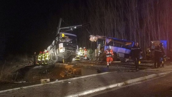 Image: Rescue workers are seen on the site of collision between train and school bus in Millas