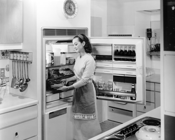 Image: A woman stocks the fridge