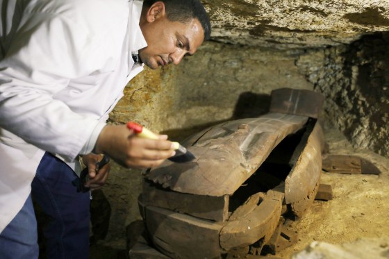 Image: An Egyptian antiquities worker brushes a coffin inside the recently discovered burial site in Minya, Egypt on Feb. 24, 2018.