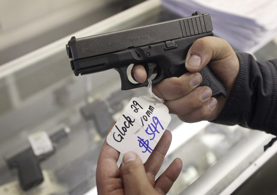 Image: A customer looks at a Glock 29 10mm hand gun at the Guns-R-Us gun shop in Phoenix