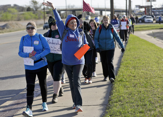 Julie Reagle, a teacher at Edison Preparatory School, waves to supporters as educators walk from Tulsa to the Oklahoma state Capitol to protest education funding on Wednesday.