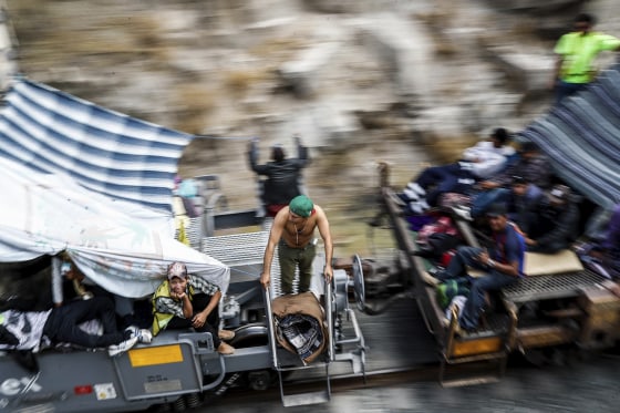 Image: Central American migrants ride a northern-bound train known as \"La Bestia,\" or The Beast, as they arrive to Hermosillo