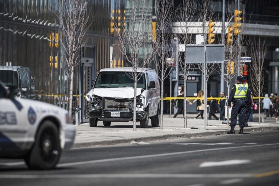 Image: Toronto police officers stand near a damaged van