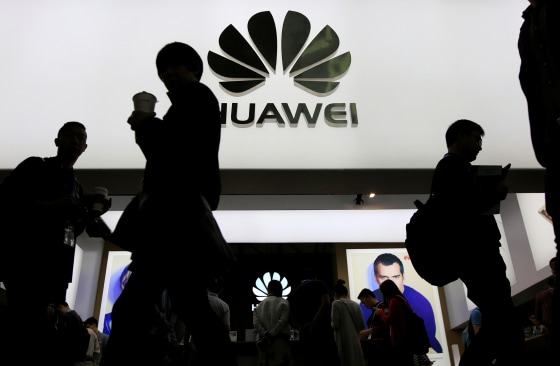 Image: People walk past a sign board of Huawei at CES Asia 2016 in Shanghai