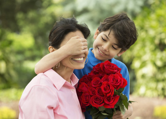 Image: Hispanic boy giving mother bouquet of roses