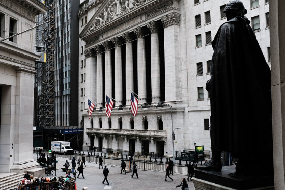 Image: People walk by the New York Stock Exchange (NYSE) before the Opening Bell