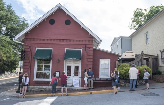 Passersby gather to take photos in front of the Red Hen Restaurant in Lexington, Virginia.