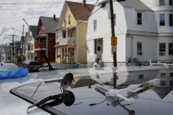 Image: A full syringe, empty syringe and spoon on the roof of the car in which a man in his 20's overdosed on an opioid