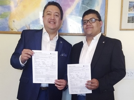 David Quiroa and son David Quiroa, Jr., hold their candidacy papers in Newport, Rhode Island on June 26.