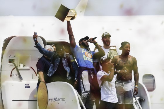 Cleveland Cavaliers' Lebron James holds up the NBA Championship trophy