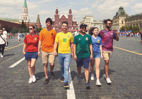 Image: Gay rights activists, wearing soccer jerseys to form a rainbow flag, walk in Red Square in Moscow