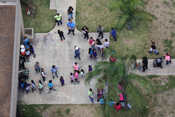 Image: Migrant children make their way inside a building at Casa Presidente in Brownsville