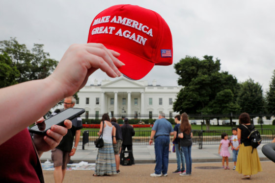 Image: A tourist holds a \"Make America Great Again\" hat outside the White House in Washington