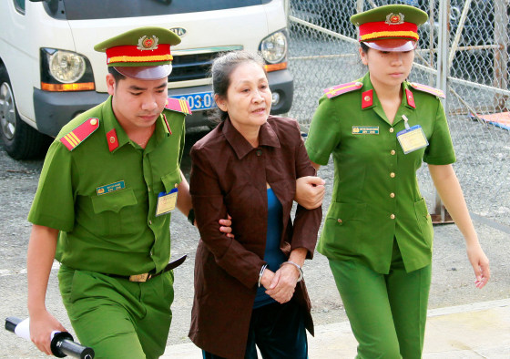 Image: U.S. citizen Angel Phan is escorted by police to a court before her trial in Ho Chi Minh city