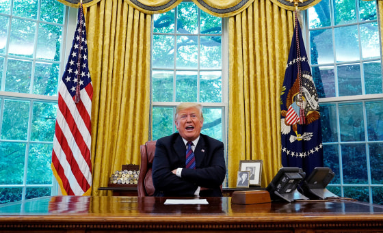 Image: President Trump sits behind his desk as he makes an announcement on NAFTA in Oval Office in Washington