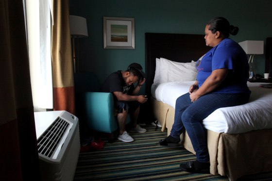 Image: Puerto Rican Miguel Alvarez and his wife Liz Vazquez sit in a hotel room where they live in Orlando