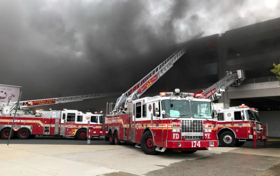 Firemen work at the scene of a Brooklyn mall parking garage fire in New York on Monday, Sept. 17, 2018.