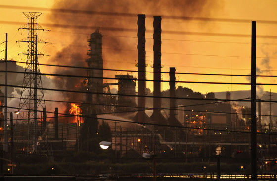 Image: Firefighters douse a flame at a Chevron oil refinery in Richmond, California
