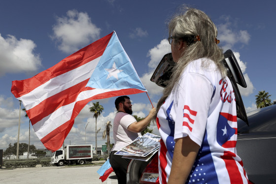Image: Aaron and Diana Umpirerre gather in the parking lot to meet others to head to West Palm Beach for a protest Sept. 22, 2018 in Hollywood, Florida.