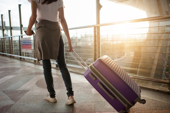 Image: Woman in airport with suitcase