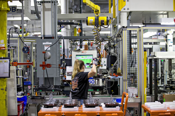 Image: An employee moves a flywheel assembly at the Harley-Davidson Inc. facility
