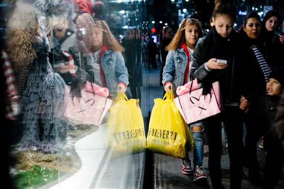 Image: People carry shopping bags outside a shopping mall