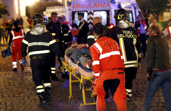Image: Fire fighters and medical staff member carry an injured person outside the underground where some of CSKA Moscow supporters were injured in Rome