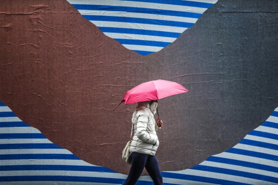 Image: A pedestrian walks under an umbrella during the rain in Manhattan