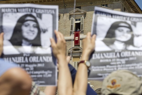 Image: Demonstrators hold pictures of Emanuela Orlandi, as Pope Benedict XVI, background center, reads his message during the Regina Coeli noon prayer in St. Peter's square at the Vatican