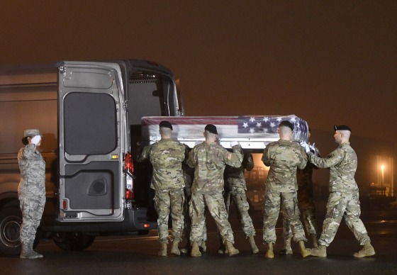 Image: An Army carry team loads into a vehicle a transfer case containing the remains of Maj. Brent R. Taylor at Dover Air Force Base