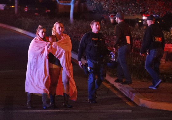 Image: Two women wearing blankets leave the area near the Borderline Bar and Grill in Thousand Oaks, California