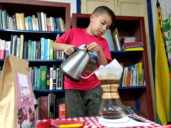 Julian Murillo, 8, pours a chemex-method coffee during the Cafeteritos after school program in the library in Marsella, Risaralda, Colombia.