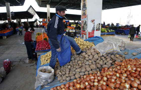 Image: A vendor sells potatoes and onions in an open market in central Ankara