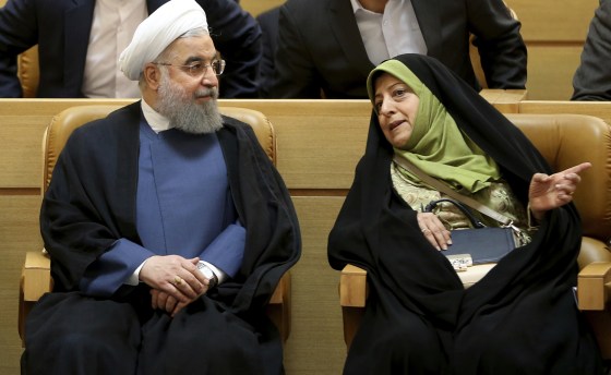 Iranian President Hassan Rouhani listens to Masumeh Ebtekar during a conference
