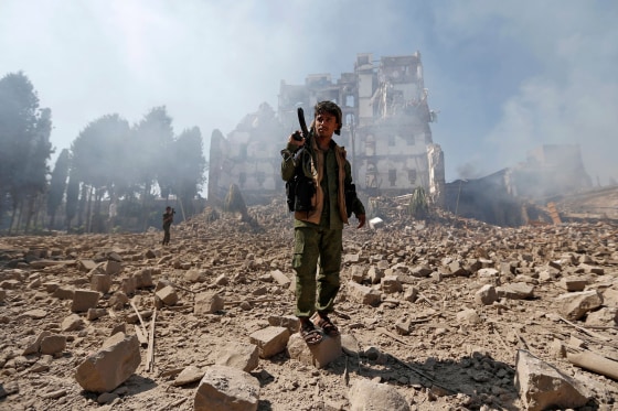Image: Huthi rebel fighters inspect the damage after a reported air strike carried out by the Saudi-led coalition targeted the presidential palace in the Yemeni capital Sanaa