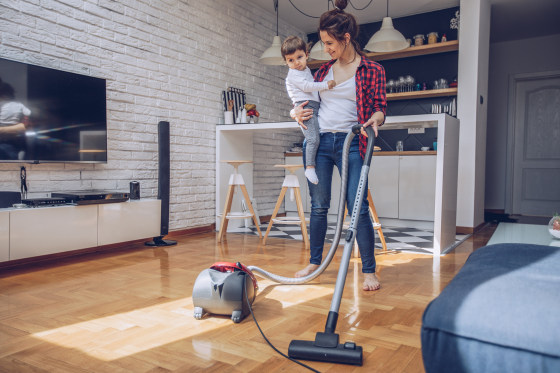Image: Young woman using vacuum cleaner
