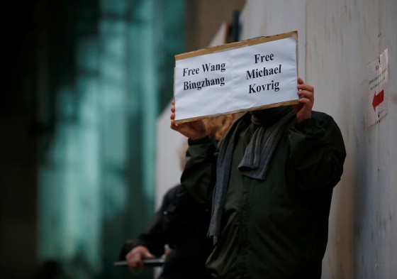 Image: A man holds a sign calling for China to release Wang Bingzhang and former Canadian diplomat Michael Kovrig, who was arrested in China, at the B.C. Supreme Court bail hearing of Huawei CFO Meng Wanzhou in Vancouver
