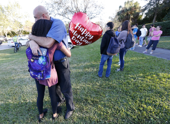 Image: Family members embrace following the shooting at Marjory Stoneman Douglas High School in Parkland, Florida.
