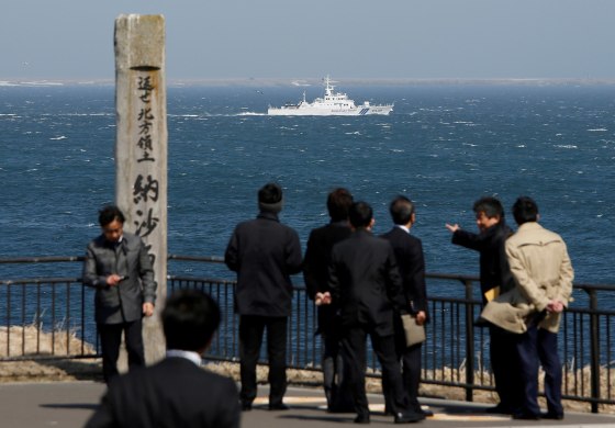 Image: A Japanese Coast Guard vessel PS08 Kariba sails off Cape Nosappu in Nemuro on Japan's Hokkaido island, with part of the islands known as the Northern Territories in Japan and the Southern Kurils in Russia visible the background