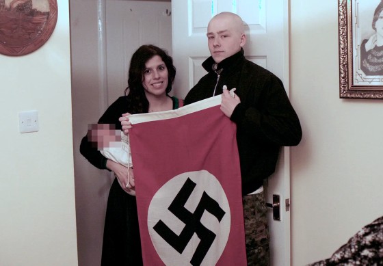 Image: Claudia Patatas and Adam Thomas pose with their son, whose middle name is Adolf.