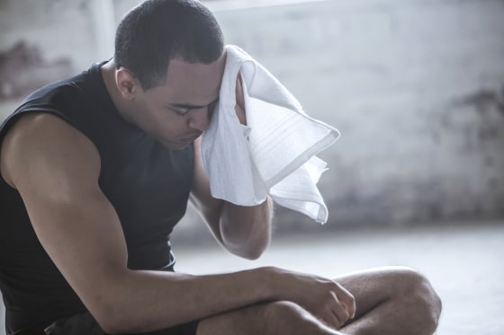 Image: Athlete wiping sweat with towel