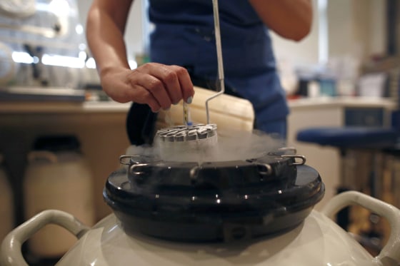 Image: An employee arranges a test tube in a container used to freeze human eggs in a laboratory